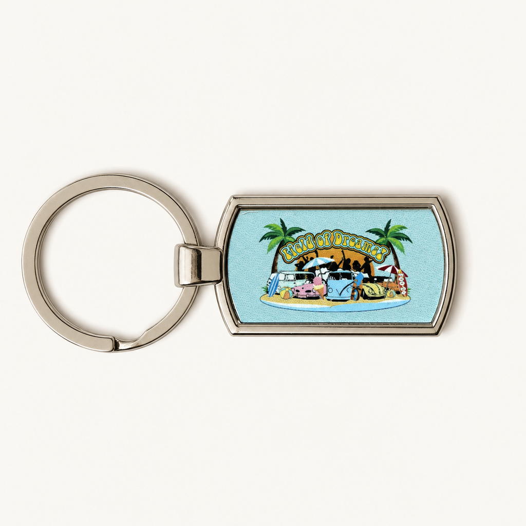 A silver metal dog tag keychain featuring a colorful illustration of a beach scene with the text 'SUNSHINE BEACH' and cartoon cow characters, set against a light cream background.